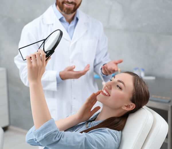 Dentist showing patient the result of implants