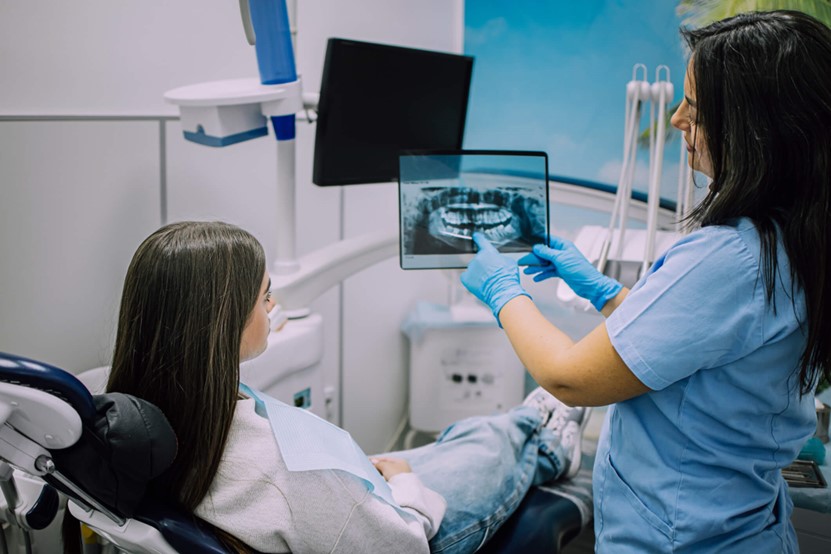 A dentist showing a patient x-ray