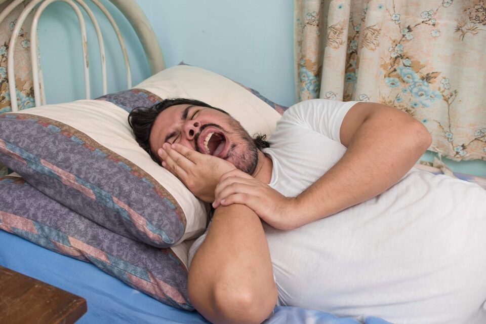 A person experiencing tooth pain in bed
