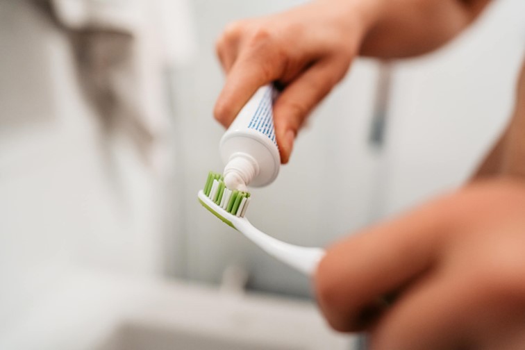 A person holding a toothbrush with toothpaste