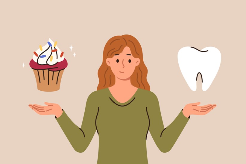 A person holding her hands up to a tooth and a cupcake