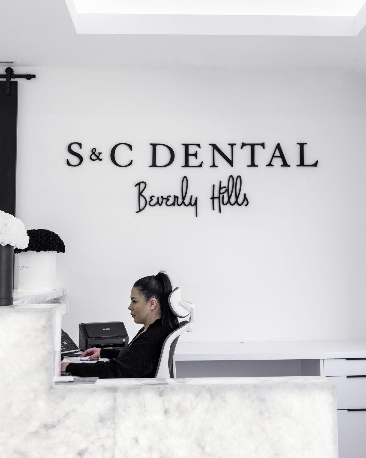 The reception desk at S&C Dental Beverly Hills, with a team member at the front desk