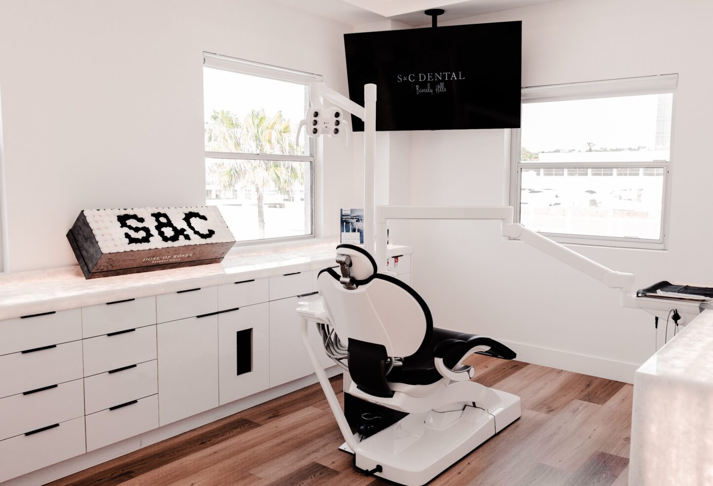 A treatment chair and overhead screen in a treatment room at S&C Dental Beverly Hills
